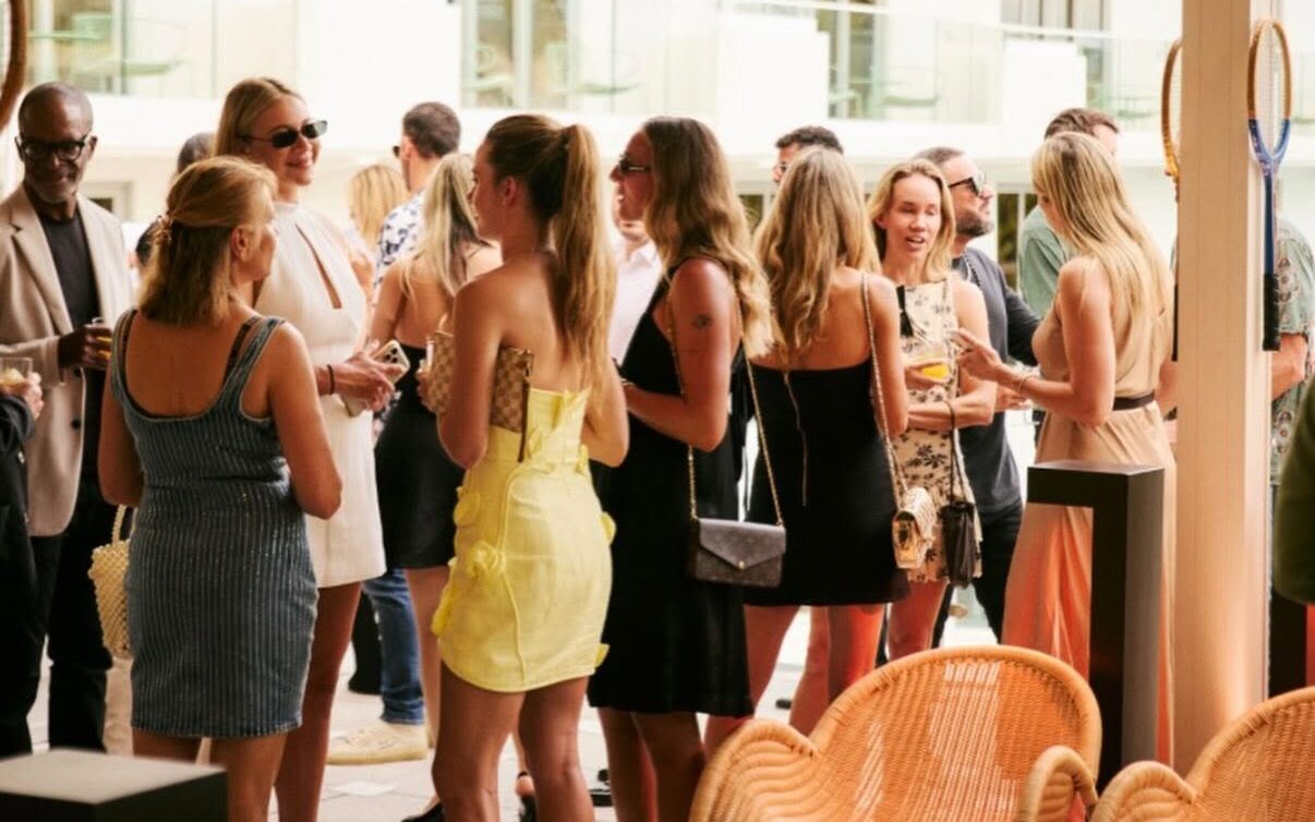Guests mingling at an event on a sunny terrace